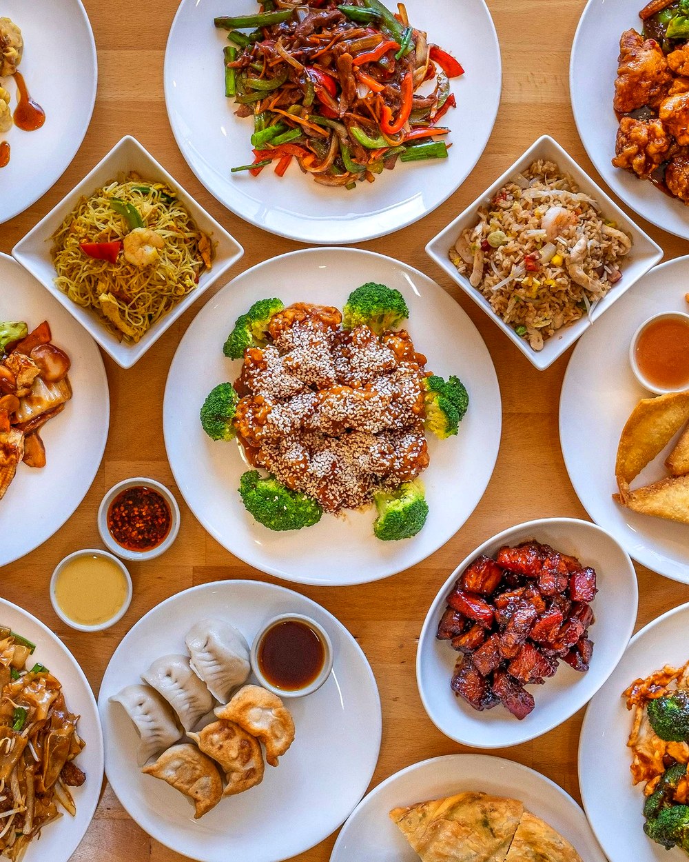 A spread of Chan's Peking Kitchen dishes including sesame chicken, dumplings, lo mein, fried rice, and more